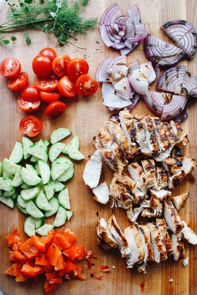 ingredients for greek chicken salad on a cutting board