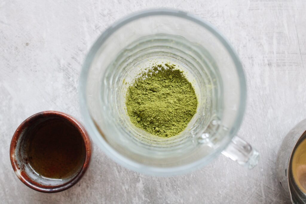 vanilla matcha latte - matcha powder in the bottom of a drinking glass