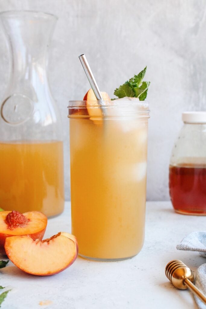 starbucks copycat iced peach green tea in a clear glass jar with mint