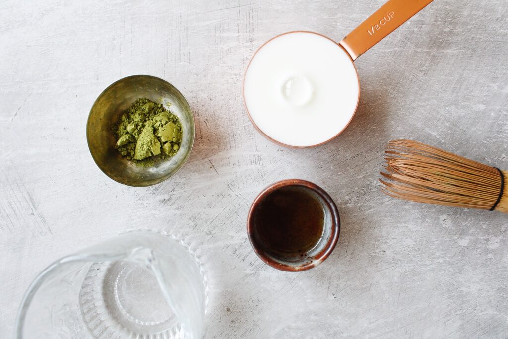 vanilla matcha latte ingredients on a gray background