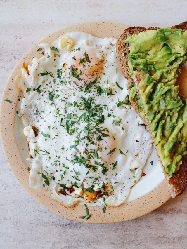 feta fried eggs on a plate with avocado toast