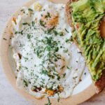 feta fried eggs on a plate with avocado toast