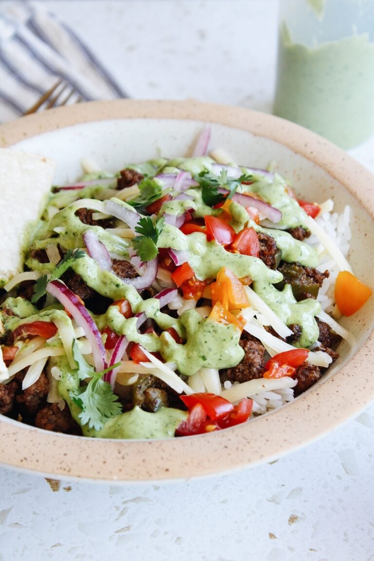 ground beef taco bowls with cream cilantro sauce in a bowl