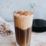 pumpkin cold foam coffee in a clear glass