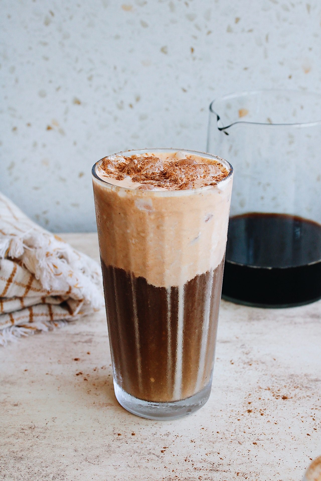 pumpkin cold foam coffee in a clear glass