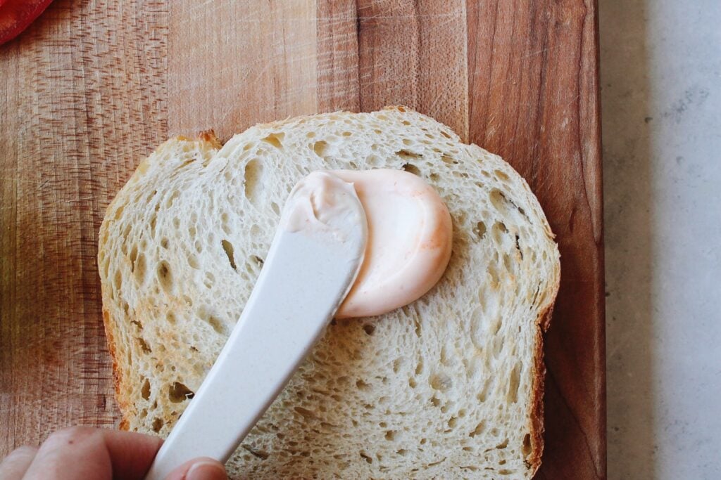 Sriracha mayo being applied to bread