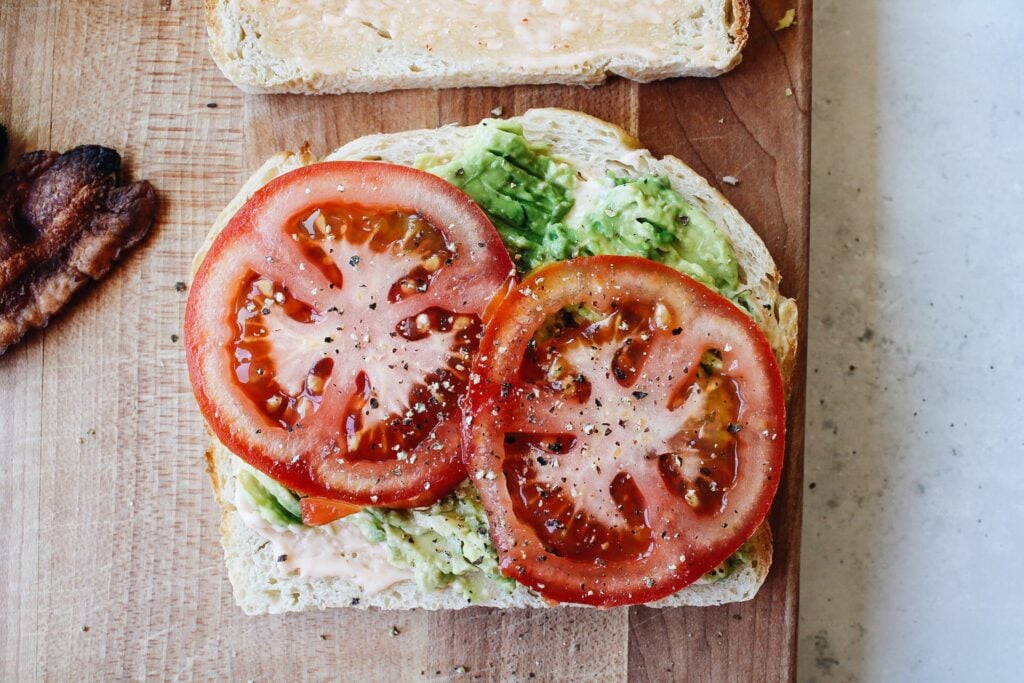 Tomato slices and black pepper on avocado 