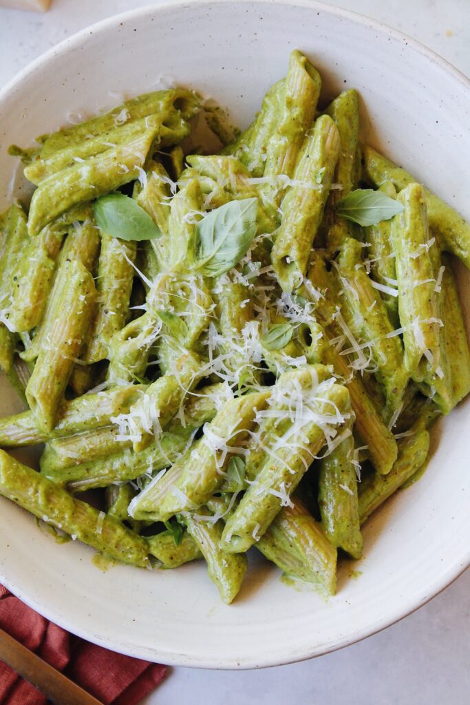 pesto without garlic on penne pasta in a white bowl