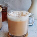 rooibos latte in a clear mug topped with cinnamon