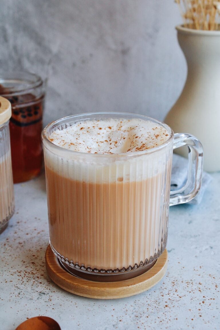 rooibos latte in a clear mug topped with cinnamon