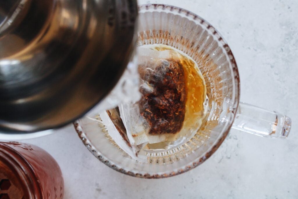 boiling water being poured over tea bags in mug