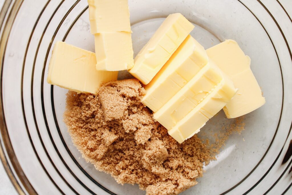 Cubed cold butter and brown sugar ina mixing bowl