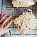 cherry scones with vanilla icing on a wire cooling rack