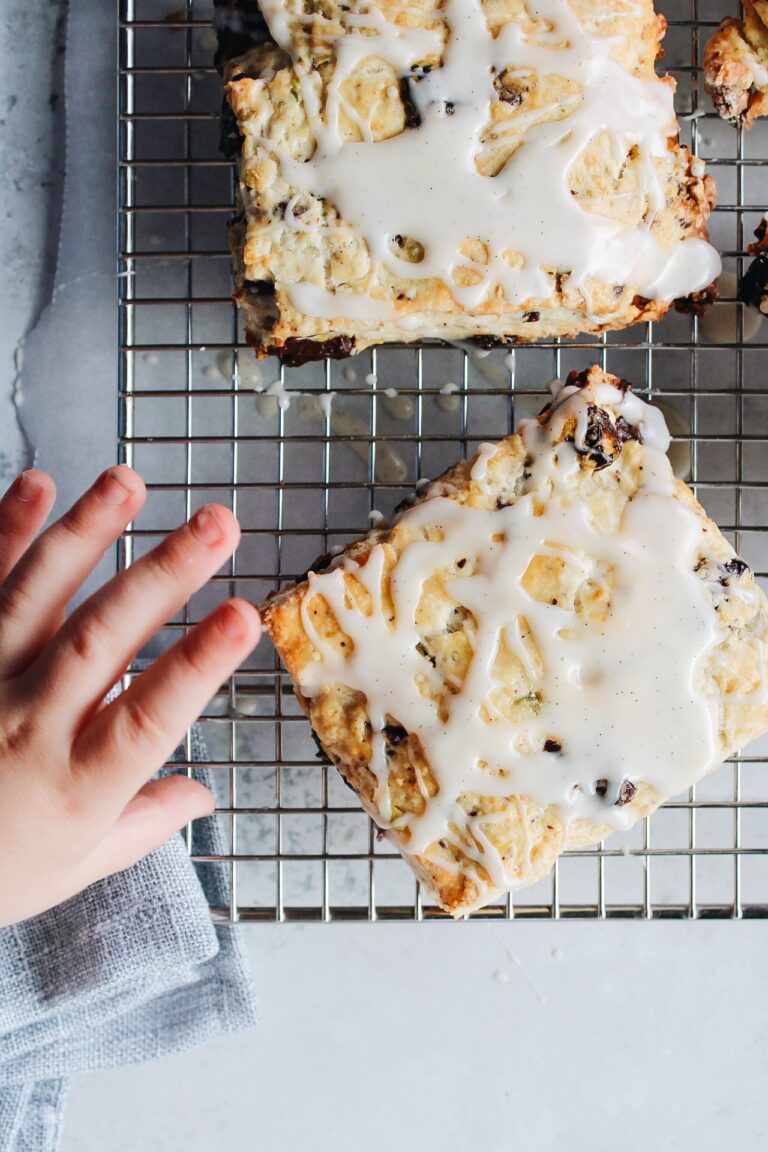 cherry scones with vanilla icing on a wire cooling rack