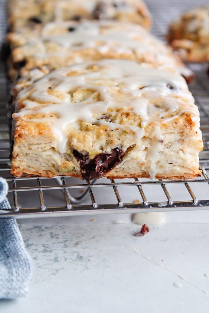 cherry chocolate scones on a cooling rack with vanilla icing