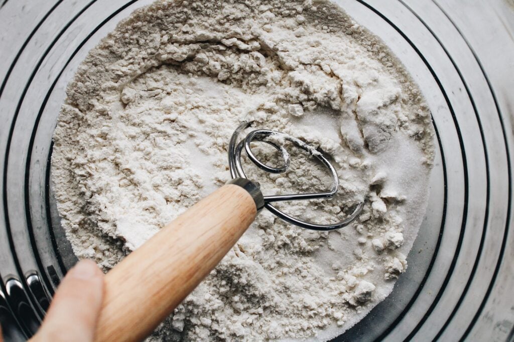 flour, baking power and salt being whisked in a mixing bowl