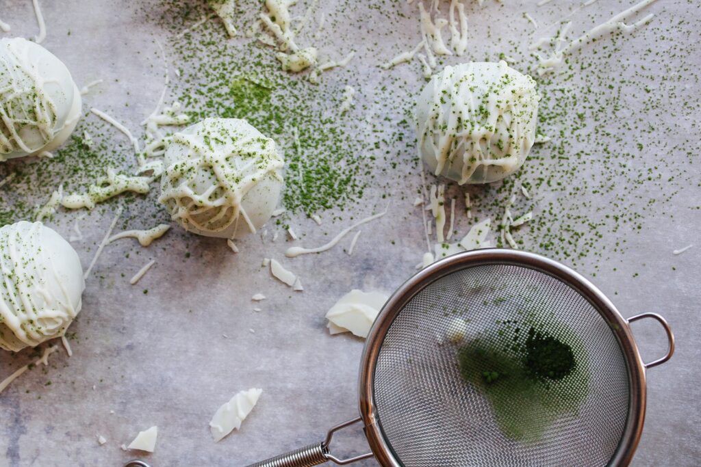 finished matcha truffles being dusted with matcha powder