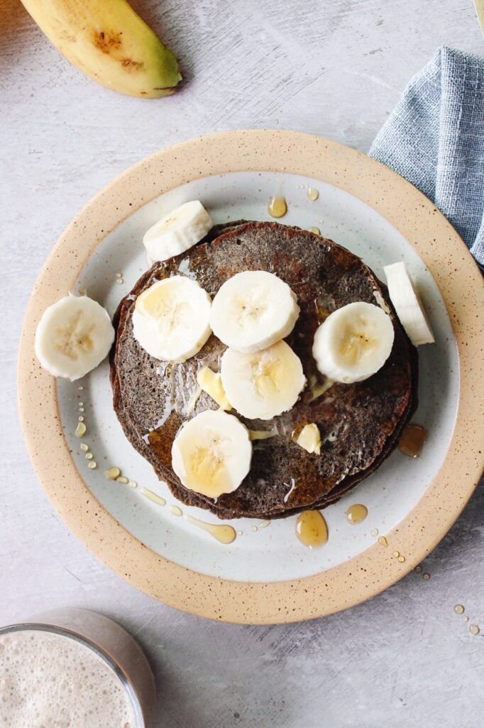 top down view of buckwheat banana pancakes on a plate with sliced bananas