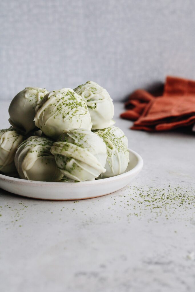 matcha truffles stacked on a white plate