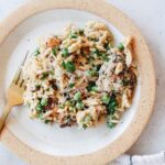 boursin chicken orzo on a beige plate with a striped napkin