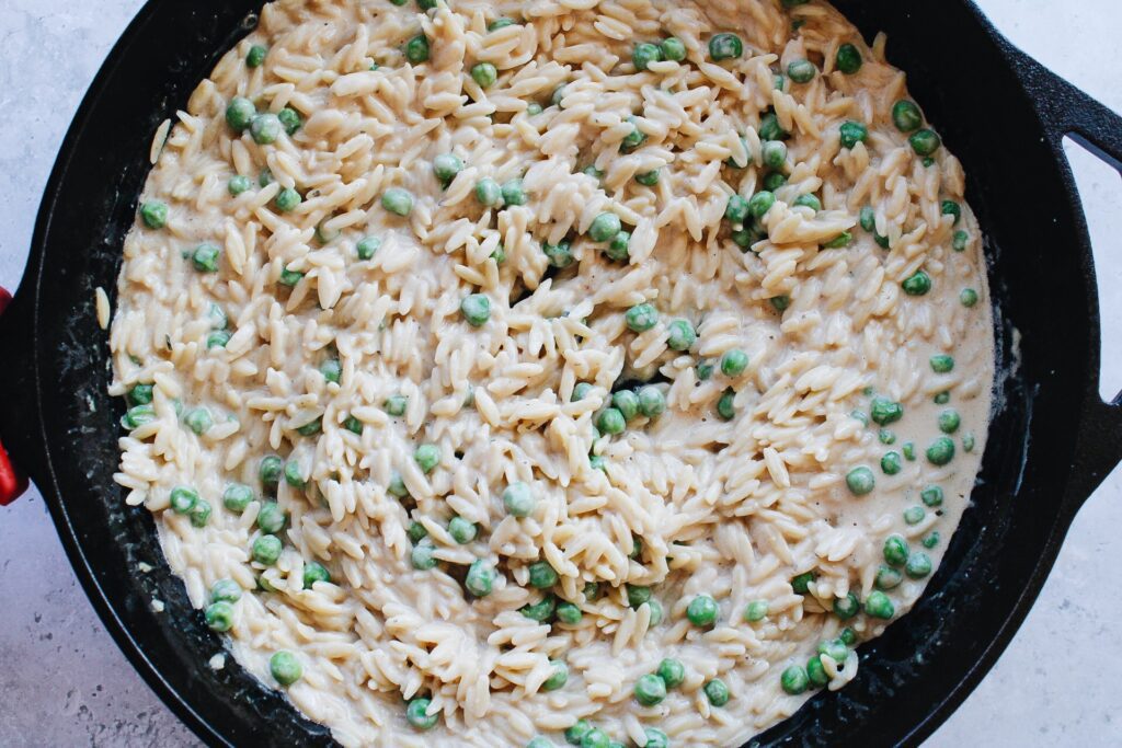 boursin orzo with peans in cast iron pan