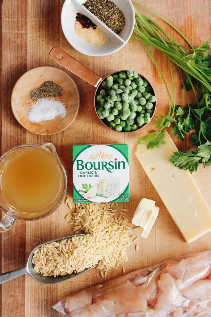 ingredients for boursin chicken orzo recipe arranged on a wooden cutting board