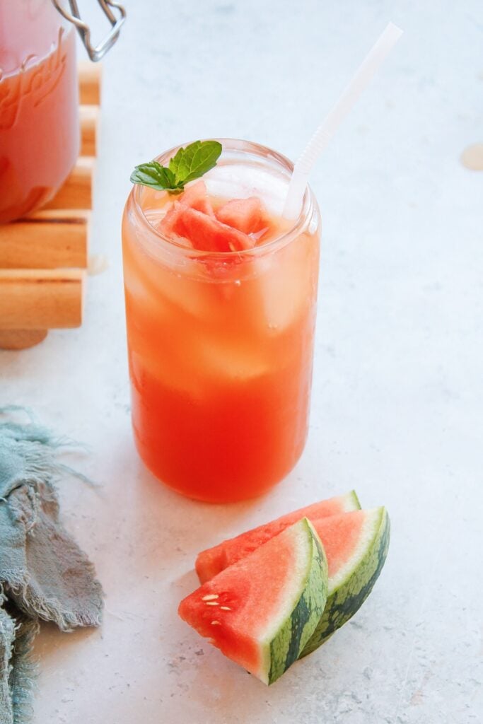 side view of watermelon green tea in a glass with mint