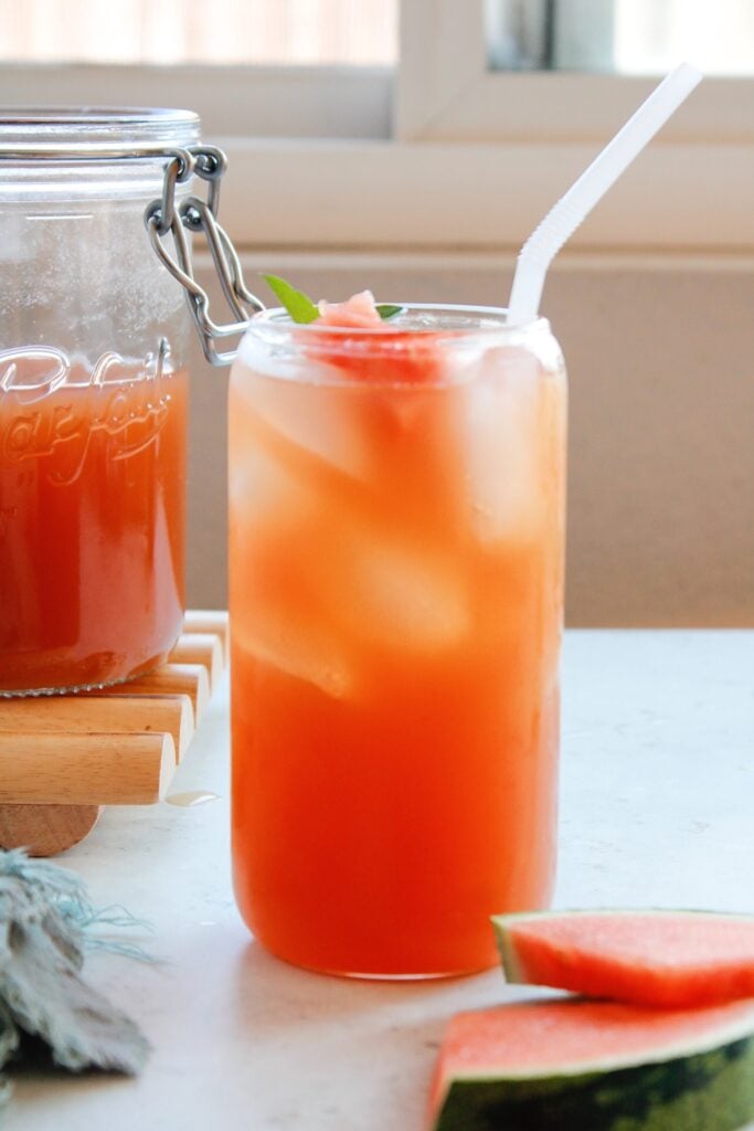 watermelon green tea on a table with a white straw