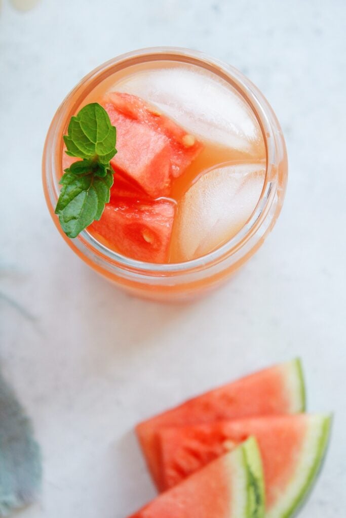 top-down view of watermelon green tea in a glass with mint