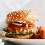 ground chicken burger on a plate with tater tots