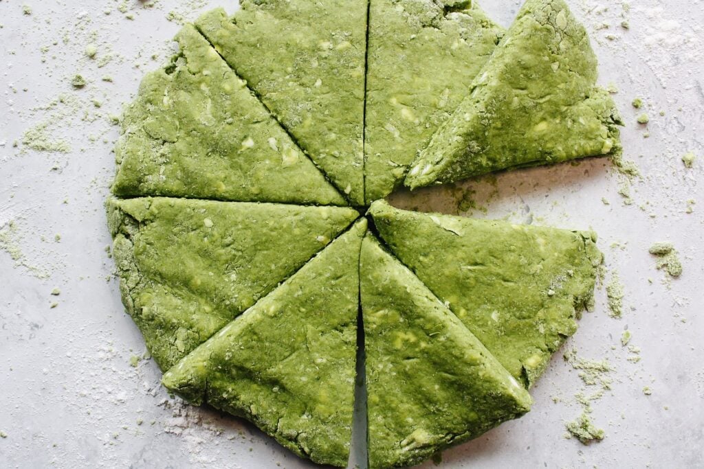 matcha scone dough shaped into a disc and cut into eight wedges