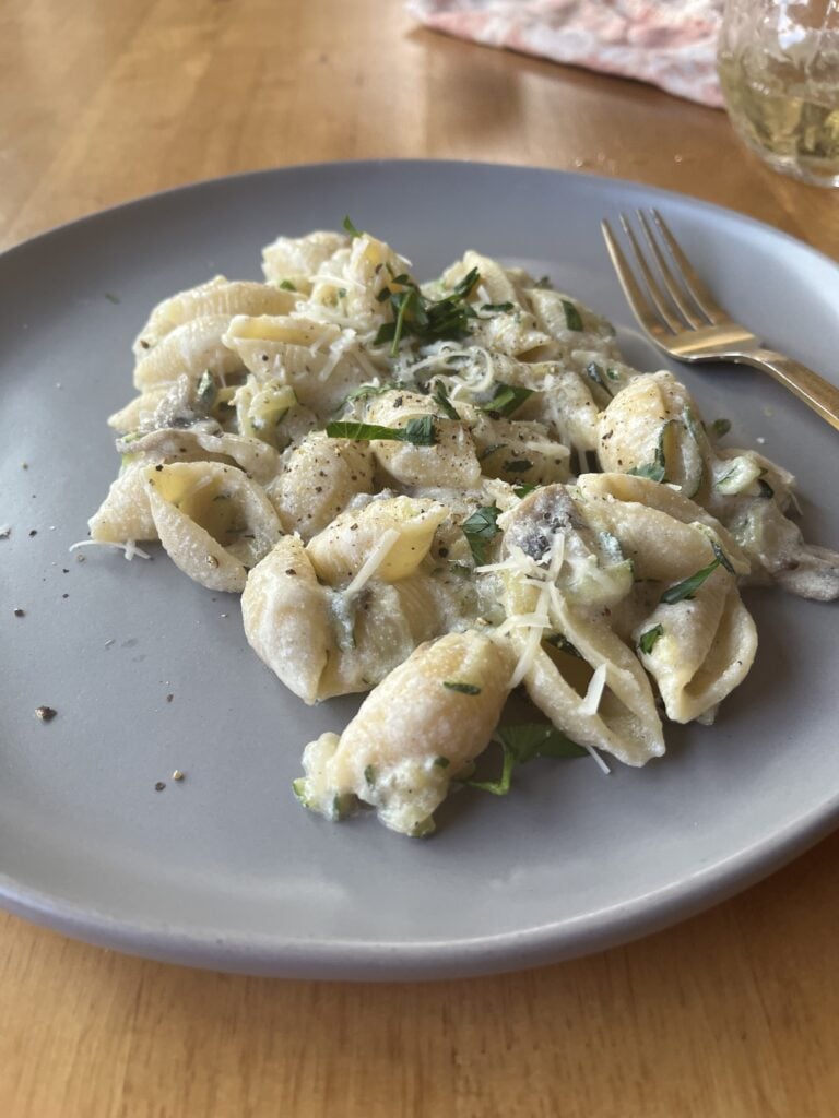 creamy zucchini mushroom pasta on a gray plate