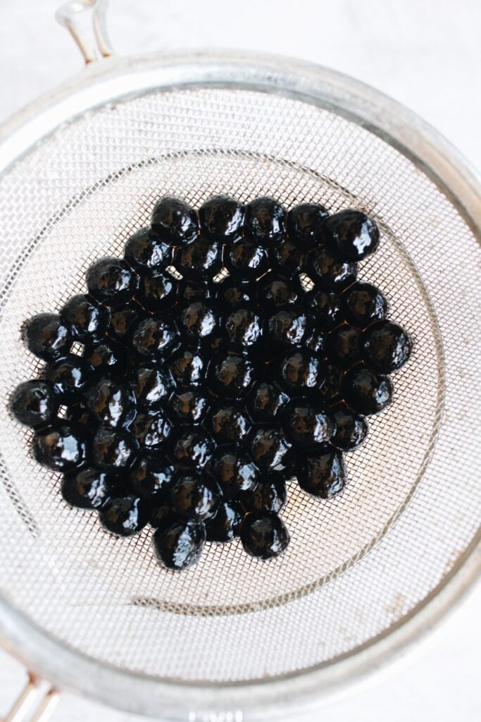 boba pearls being strained through a sieve